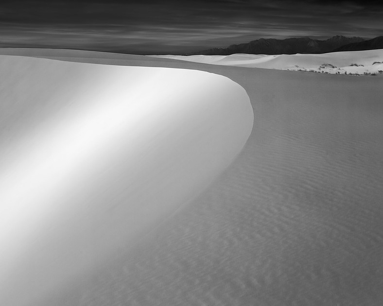 Sand Dune with Sweeping arc in black and white with mountains in the background